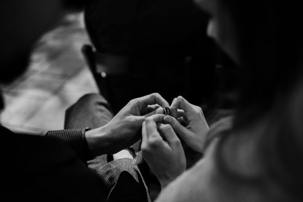 Ring warming ceremony with two people holding wedding rings