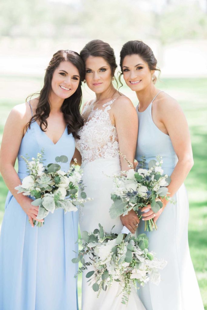 Bride and her sisters holding bouquets with green and white flowers