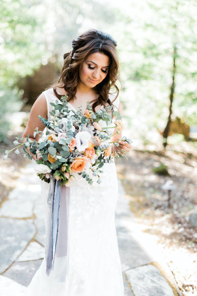Close up of bride holding peach and white bridal bouquet at Calistoga Ranch
