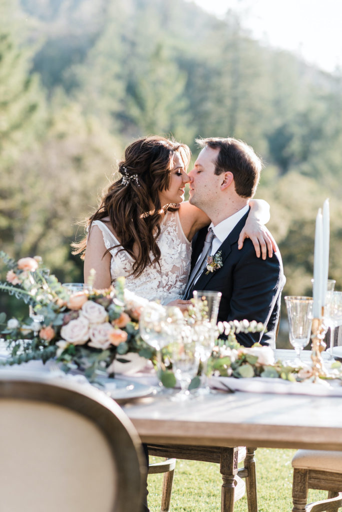bride and groom kiss at reception table at Calistoga Ranch