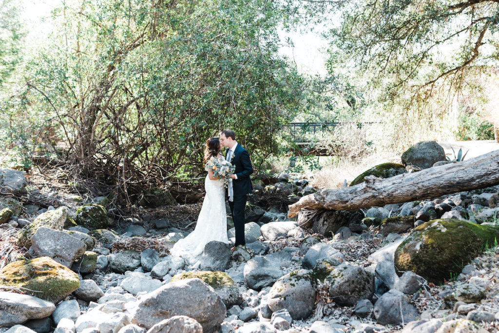 bride and groom kiss while standing on rock at Calistoga Ranch
