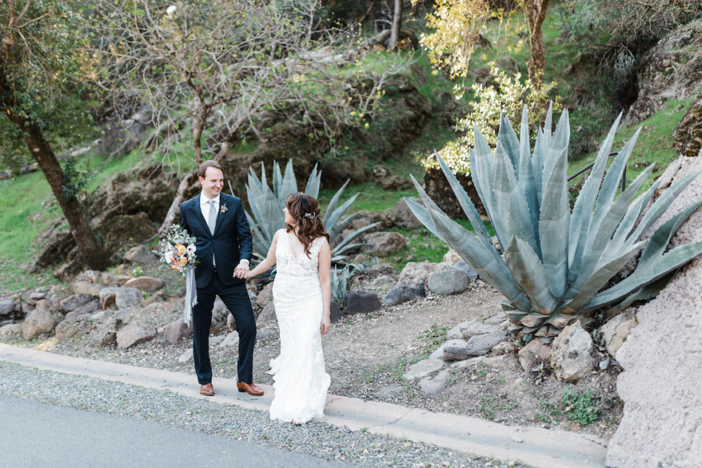 bride and groom pose in front of large succulents at Calistoga Ranch