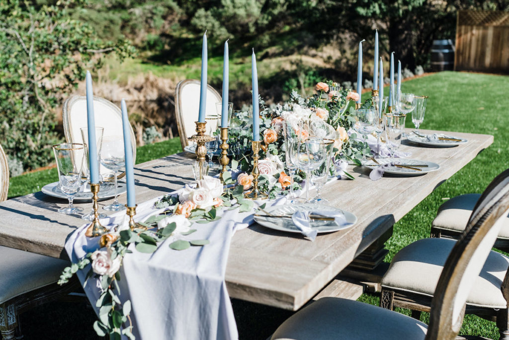 gray wooden farm table with gray and lavender reception decor at at Calistoga Ranch